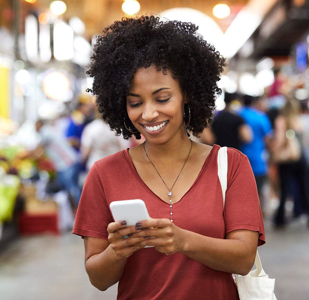 Lady multitasking on phone with her young son drawing.