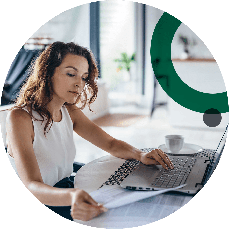 Business woman using computer and reviewing papers