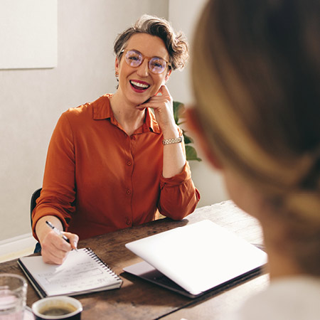 Women discussing business details together.