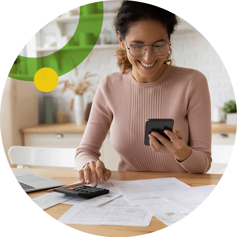 Smiling business woman using phone and calculator