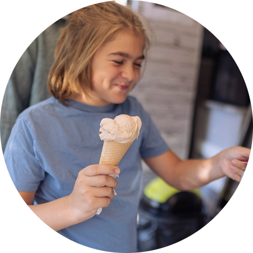 Child holds an ice cream cone after making a purchase.
