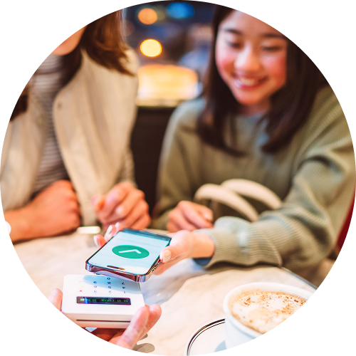 Teen uses a mobile device for a contactless payment transaction.