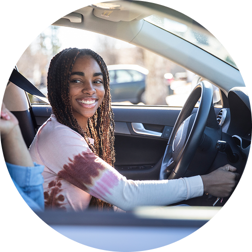 Teen sits behind the wheel while learning to drive.